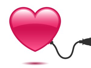 roze hart met een zwarte stekker die in de muur in het stopcontact zit
